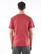 Remera de corte regular, color verde oliva, con cuello redondo y mangas cortas, confeccionada en tejido de punto con textura sutil.