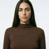 Polera de manga larga en color negro, con cuello alto y costuras decorativas visibles en el frente que realzan la silueta.