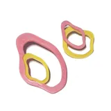 Par de aros colgantes con forma orgánica, compuestos por dos aros entrelazados de resina color rosa y amarillo.