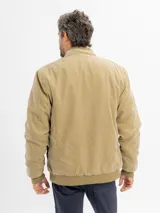 Campera de estilo casual color beige, con cierre frontal, cuello alto y puños elásticos acanalados.