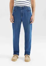 Pantalón de jean de corte slim, color azul clásico, con cierre de botón y cremallera, bolsillos laterales y traseros.