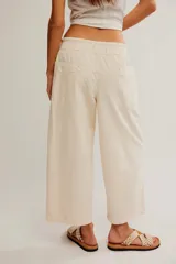 Pantalón de denim blanco de tiro medio con cintura elástica ajustable mediante cordón, bolsillos plaqué delanteros y diseño de corte amplio y holgado.