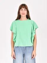 Remera verde de algodón con cuello redondo y mangas cortas con volados laterales.