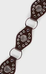 Cinto marrón de cuero con apliques metálicos plateados y argollas.