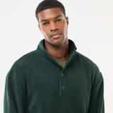 Sweater de polar verde con cuello alto tipo camionero y cierre frontal con botones a presión. Diseño de manga larga con puños elásticos.