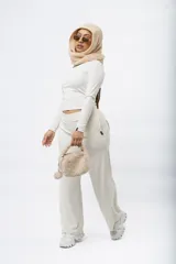 Pantalón palazzo de punto acanalado color marrón oscuro, con cintura elástica y corte holgado.