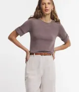 Blusa de viscosa color marrón topo, con cuello redondo y mangas cortas. Presenta aplicaciones de encaje tipo entremedios en las mangas y en la zona de los hombros.