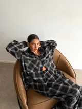 Pantalón de corte recto y holgado, confeccionado en tela de viyela con estampado de cuadros en tonos negro, gris y blanco. Presenta cintura elástica para mayor comodidad.