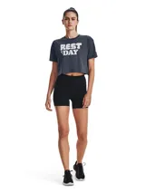 Remera de corte cropped Under Armour, color gris oscuro, con cuello redondo acanalado y estampa frontal con la frase 'REST DAY' en tipografía blanca estilo nube.