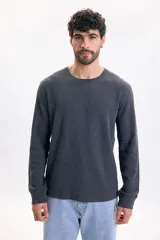 Remera de manga larga gris oscuro con textura waffle, cuello redondo y puños elásticos.