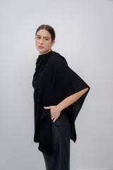 Ruana negra de tejido de punto grueso, confeccionada en 100% baby alpaca.