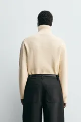 Jersey de punto con cuello perkins y cierre frontal con solapa oculta. Presenta diseño de manga larga con terminaciones en rib.