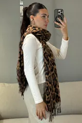 Bufanda rectangular con estampado animal print en tonos blanco y negro, con terminaciones de flecos en los extremos.
