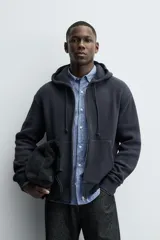 Sudadera hoodie relaxed fit color azul marino, confeccionada en tejido waffle con estructura cuadrillé. Cuenta con capucha ajustable, manga larga, bolsillos delanteros tipo canguro, acabados en rib y cierre frontal de cremallera. Presenta un efecto lavado.