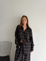 Pantalón de corte recto y holgado, confeccionado en tela de viyela con estampado de cuadros en tonos negro, gris y blanco. Presenta cintura elástica para mayor comodidad.