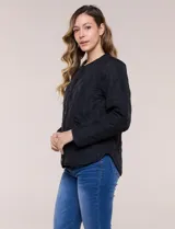 Campera matelaseada color verde militar con diseño capitoneado de rombos, escote redondo sin cuello y cierre frontal con broches a presión. Cuenta con bolsillos frontales oblicuos y ruedo curvo con aberturas laterales.