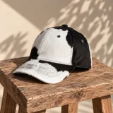 Gorro con visera de cuero con estampado tipo animal print de vaca en color blanco y negro.