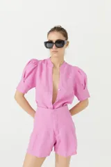 Short de lino color rosa con cintura alta, pinzas delanteras, bolsillos laterales y cierre frontal con gancho metálico.