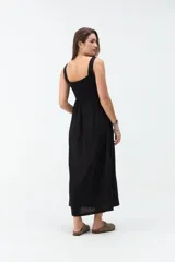 Vestido midi negro con escote cuadrado, tirantes anchos y falda de corte acampanado.
