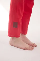 Pantalón de lino color beige, de corte recto y tiro medio, con bolsillos laterales y detalles de costuras visibles.