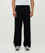Pantalón deportivo negro con rayas laterales blancas, cintura elástica, bolsillos y estampa localizada en la parte superior.
