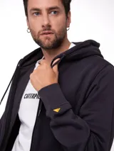 Buzo con cierre frontal de metal, capucha forrada y bolsillos tipo canguro. Presenta puños y bajo acanalados, con etiqueta de la marca en el bajo y logo en la manga.