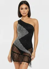 Vestido corto de un solo hombro con body incorporado. Presenta un diseño asimétrico con una franja diagonal de pedrería brillante sobre una base negra. La parte inferior está confeccionada en tejido transparente con flecos largos que aportan movimiento.