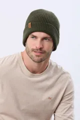 Gorro tejido de punto acanalado en color azul marino, con vuelta y etiqueta decorativa de cuero sintético en el lateral.