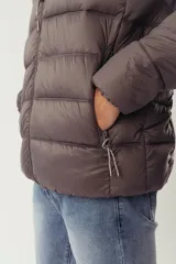 Campera puffer de invierno color azul marino, con cuello elevado, cierre frontal completo y capucha oculta. Presenta bolsillos laterales con cierre y logo en relieve en el pecho.