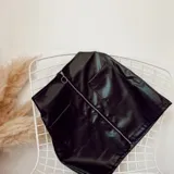 Minifalda negra de ecocuero con cierre metálico frontal y dos bolsillos delanteros.