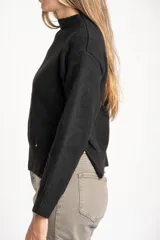 Sweater de punto color negro confeccionado en mezcla de lana lambswool y nylon. Presenta cuello alto tipo polera, manga larga y terminaciones acanaladas en puños y bajo.