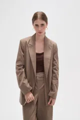 Blazer de corte holgado con diseño de rayas verticales, cuello solapa y cierre frontal con un botón. Cuenta con bolsillos laterales con solapa.