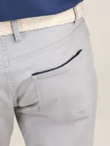 Pantalón de hombre de corte chino, color azul marino, con cinco bolsillos y ruedo doblado.