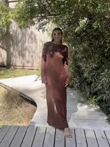 Vestido largo marrón de tejido de algodón fino y ligero, con mangas largas y escote redondo. Puede usarse con el escote hacia adelante o hacia atrás.