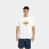Remera de corte oversize color blanco, con cuello redondo y estampado gráfico central con el logo de la marca Reef en tonos amarillo y azul.