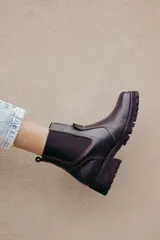 Bota tipo chelsea de cuero color marrón oscuro, con paneles laterales elásticos y suela track robusta con plataforma.