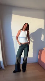 Pantalón de jean de tiro medio con diseño bicolor, combinando un tono azul oscuro en la parte superior y un tono más claro en la parte inferior. Presenta una cintura con detalle de textura tipo animal print y costuras reforzadas en las rodillas.