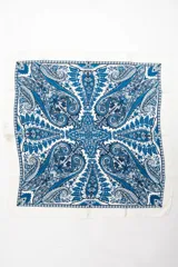 Bandana cuadrada de color blanco con diseño ornamental en tonos de azul, con estampado paisley y detalles geométricos.