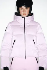 Campera puffer lila con capucha y forro negro, cierre frontal con cremallera, bolsillos laterales con cierre y puños negros ajustados.