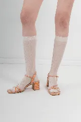Sandalias de tacón bajo con diseño de tiras finas cruzadas en el empeine y cierre de hebilla en el tobillo. Presentan una puntera cuadrada y acabado con textura efecto reptil en tonos metalizados.