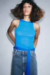 Jeans de tiro alto con corte wide leg y largo completo. Presenta diseño de cinco bolsillos, trabillas en la cintura y cierre frontal con cremallera y botón, con un acabado de efecto lavado.