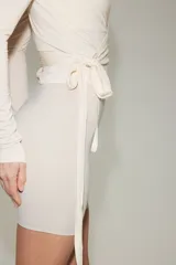 Top deportivo cruzado de modal suave, en color beige claro, con escote en V pronunciado, mangas largas y tiras para anudar en la cintura.