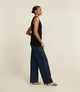 Pantalón de jean de corte wide leg, tiro alto, con bolsillos delanteros y traseros, trabillas para cinturón y cierre frontal con cremallera y botón.