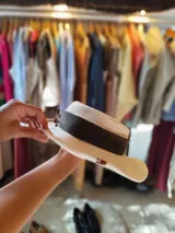 Sombrero de algodón tejido estilo fedora, color mostaza, con cinta de cuero marrón decorativa alrededor de la copa.