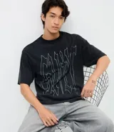 Remera de corte boxy en algodón color negro, con cuello redondo, mangas cortas y estampa frontal con lettering Guilt en color blanco.