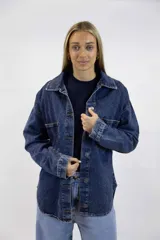 Camisa de denim azul oscuro con bolsillos frontales con solapa, cierre de botones metálicos y corte oversize.