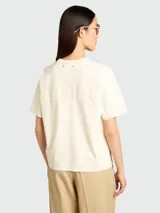Remera de algodón color crema, de corte clásico con cuello redondo y mangas cortas. Presenta un diseño minimalista y liso.
