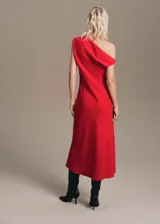 Vestido midi de corte evasé en color rojo, con diseño asimétrico de un solo hombro y detalle de fruncido. Cuenta con cierre de cremallera lateral y forro interior.