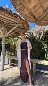 Ruana de tejido de punto color crema con diseño de líneas horizontales caladas y terminación con flecos en el ruedo.