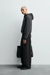 Sudadera de corte relajado confeccionada en tejido compacto de algodón con interior forrado, cuello con capucha, manga larga, bolsillos frontales tipo canguro y acabados en rib.